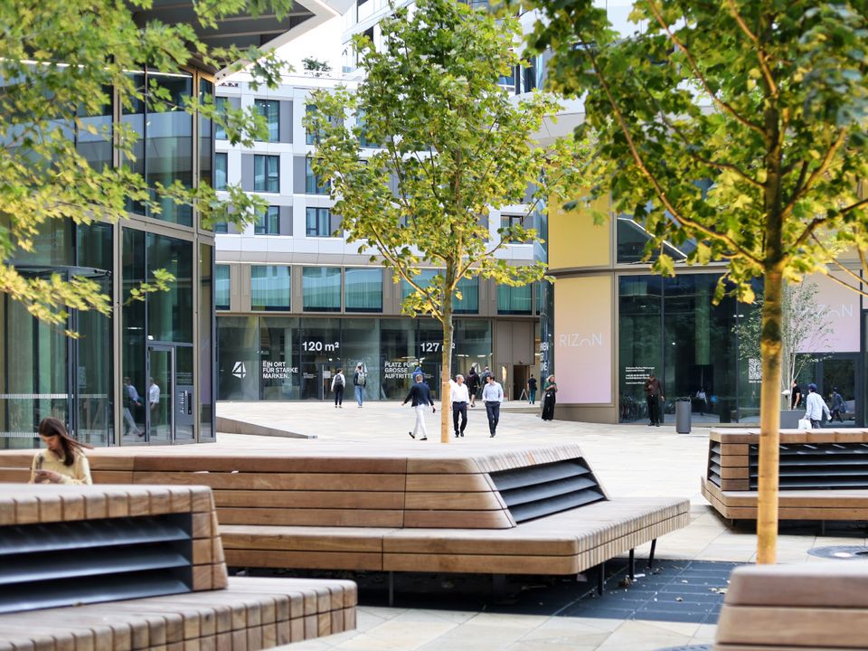 Exterior view of a high‑rise featuring glazed façade sections, vertically emphasised structural lines and adjacent urban spaces.