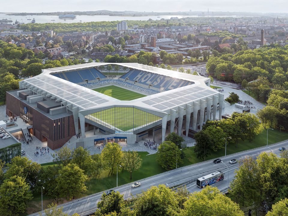 Aerial view of the stadium, highlighting the roof structure, continuous stand geometry, entrance zones and surrounding urban landscape.