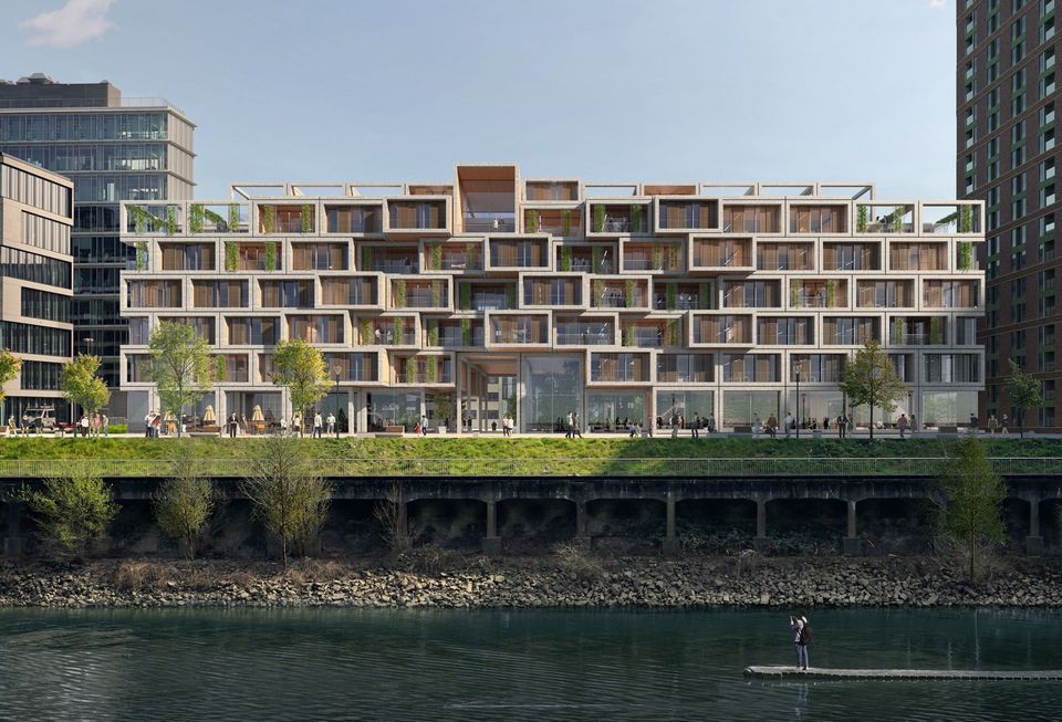 Exterior view of a terraced residential and office building along the waterfront featuring staggered room modules, landscaped roof areas and a clearly structured façade layout.