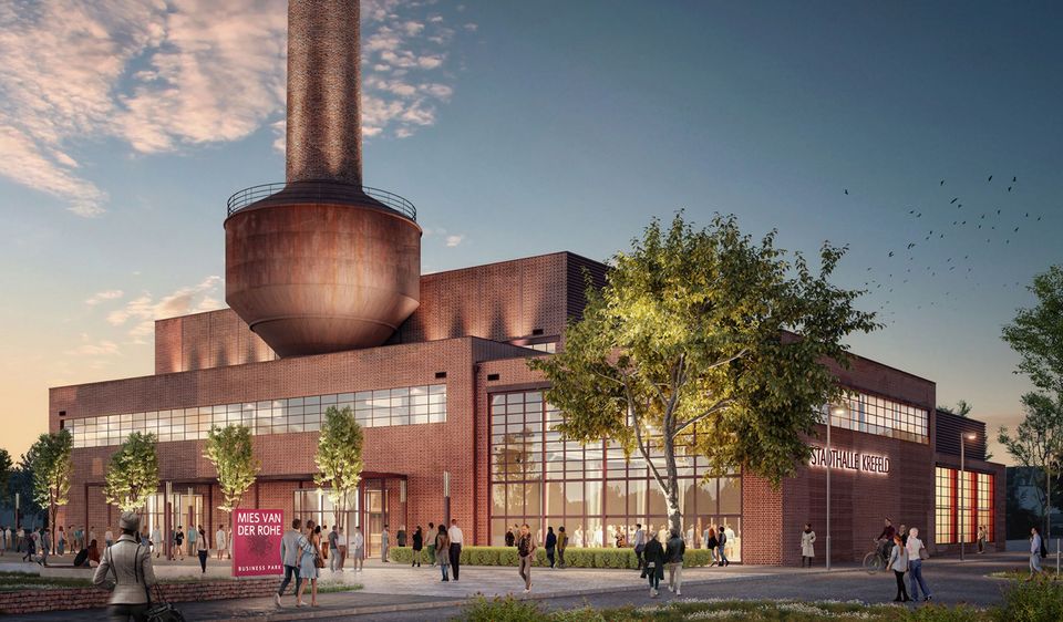 Außenaufnahme einer historischen Industriehalle mit Ziegelfassade, markantem Schornstein und neu gestalteten Eingangsbereichen, belebt durch Besucherinnen und Besucher.