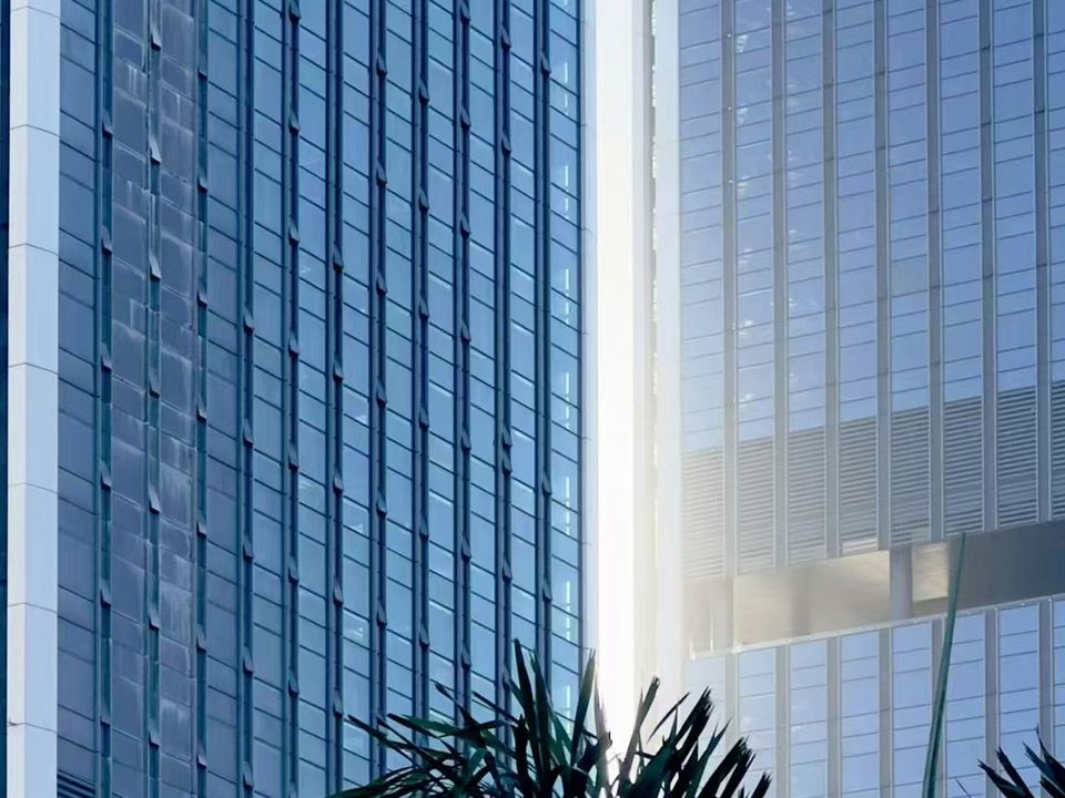 Close-up of a modern high-rise façade with vertical glass and metal elements, captured from a low-angle perspective in an urban setting.