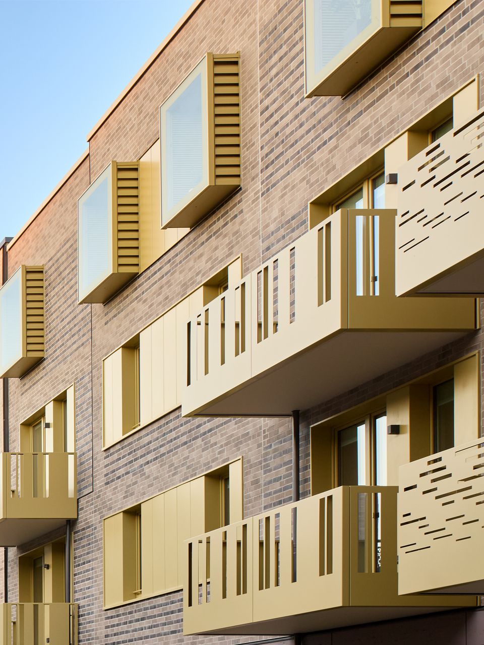 Exterior view of the façade with profiled balconies and staggered window openings of a residential building.